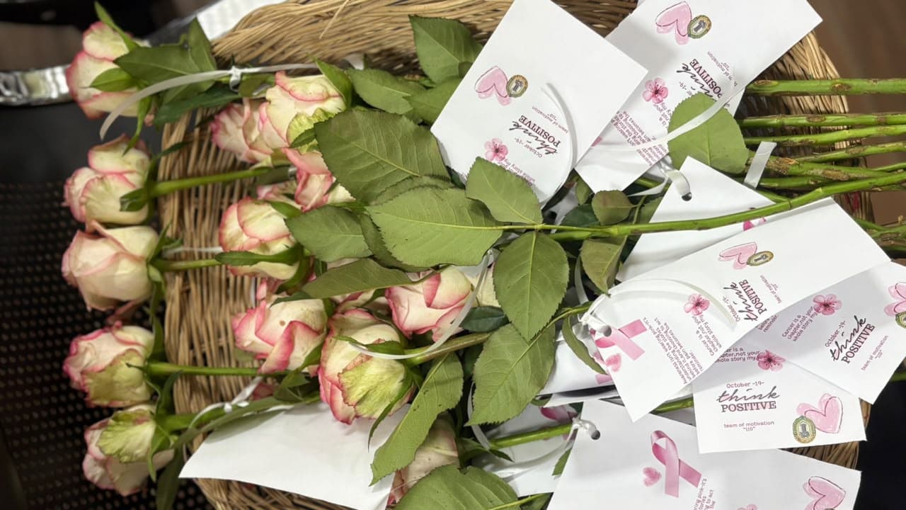 Pink-edged roses in a basket, each tied with a "think positive" card.