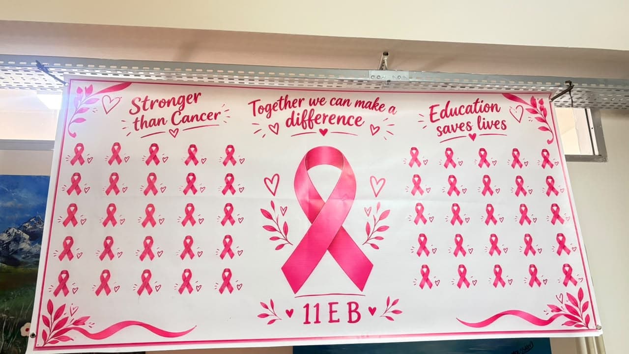 A pink-ribbon banner signed 11EB with the phrases "Stronger than Cancer", "Together we can make a difference" and "Education saves lives".